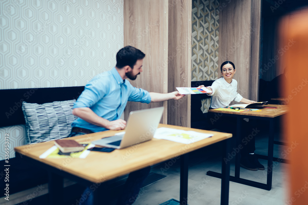 Colleagues sharing printed paper document in office