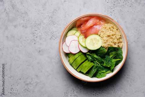 Poke bowl with salmon, spinach, quinoa, cucumber and radish. Clean Eating Concept