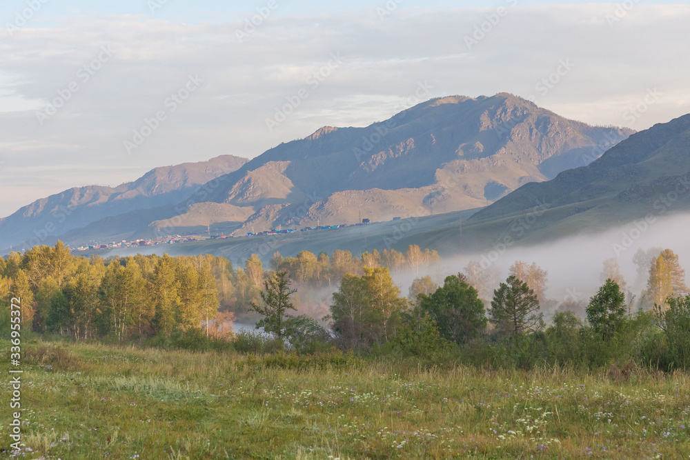 View of the Altai mountains. Alpine valley. Peaks in a blue haze.