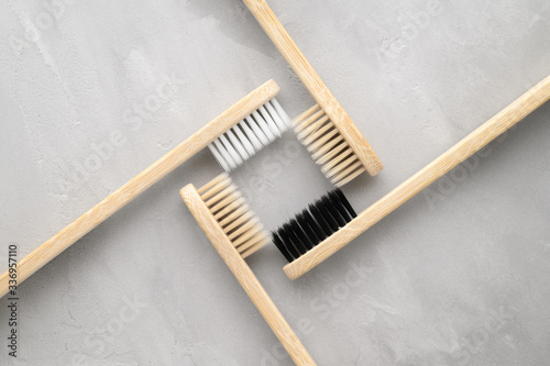 Zero waste concept. Set of eco friendly bamboo toothbrushes on a gray concrete background. Flat lay, horizontal orientation. Layout natural organic hygiene products.