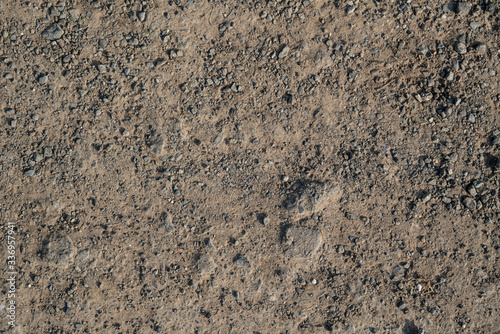 Texture of flatted dry soil as walking road with rocks