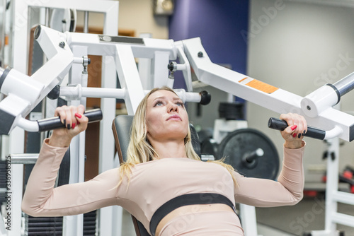 Pretty girl doing sport in the gym. Body work and active life. Sport girl is motivated and confident.
