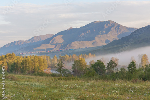 View of the Altai mountains. Alpine valley. Peaks in a blue haze.
