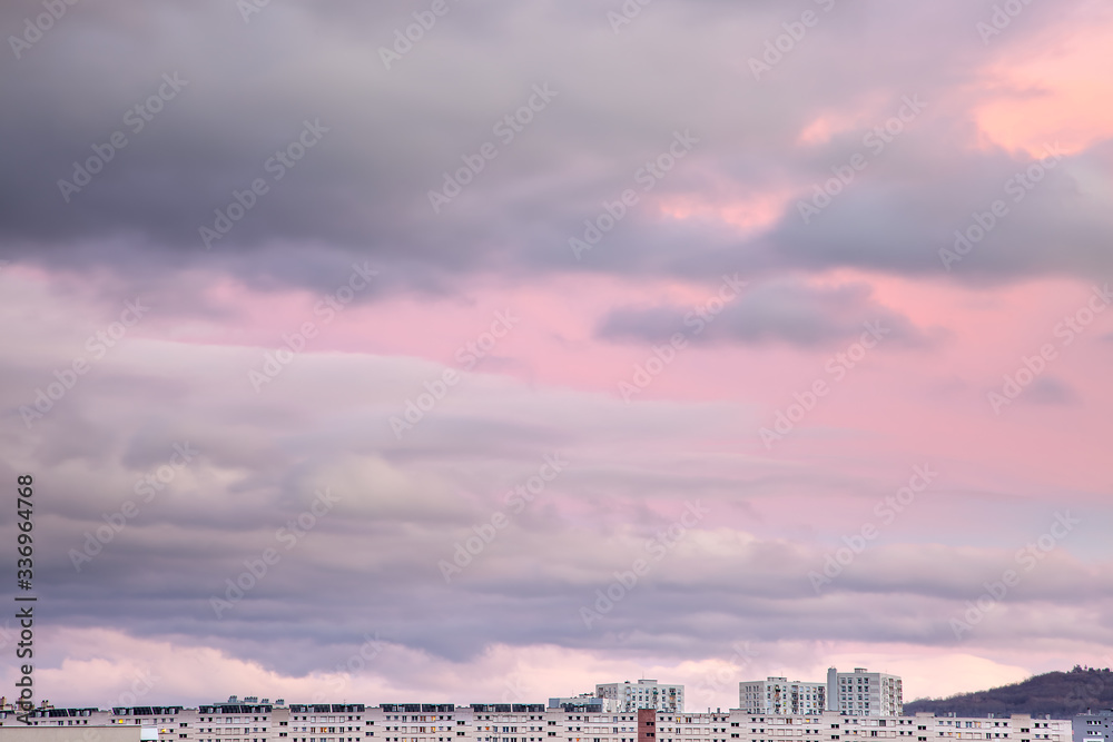 Beautiful, abstract view of the tops of the buildings in Clermont Ferrand in France and colorful, purple, cloudy sunset sky