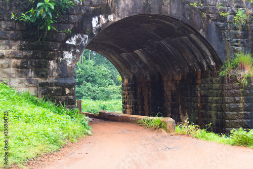 a rway under the ailway bridge made with rocks linked to nature in kerala india photo