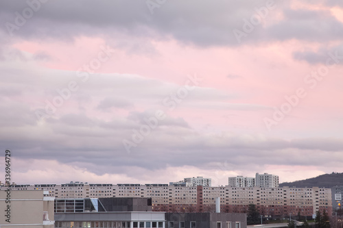 Beautiful, abstract view of the tops of the buildings in Clermont Ferrand in France and colorful, purple, cloudy sunset sky