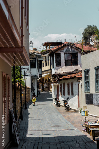 Fototapeta Naklejka Na Ścianę i Meble -  Girl walking down the sunny street of old town Kaleici, Antalya, Turkey