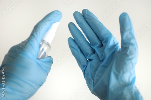 Disinfect hands in gloves. Woman sanitaze her hands by desinfactant photo