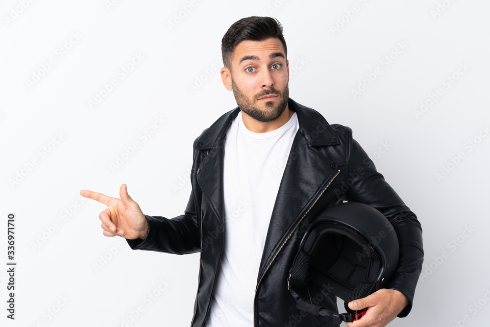 Man with a motorcycle helmet pointing to the laterals having doubts Man with a motorcycle helmet pointing to the laterals having doubts