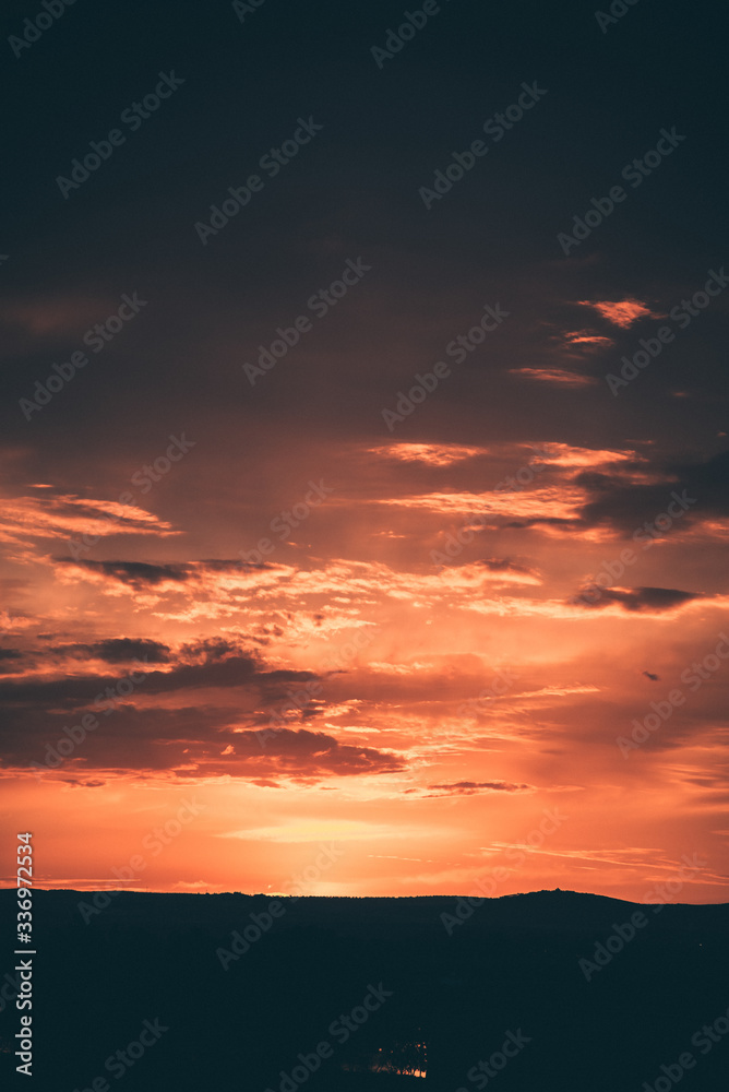 Fototapeta premium Beautiful sunset sky above clouds with dramatic light. 