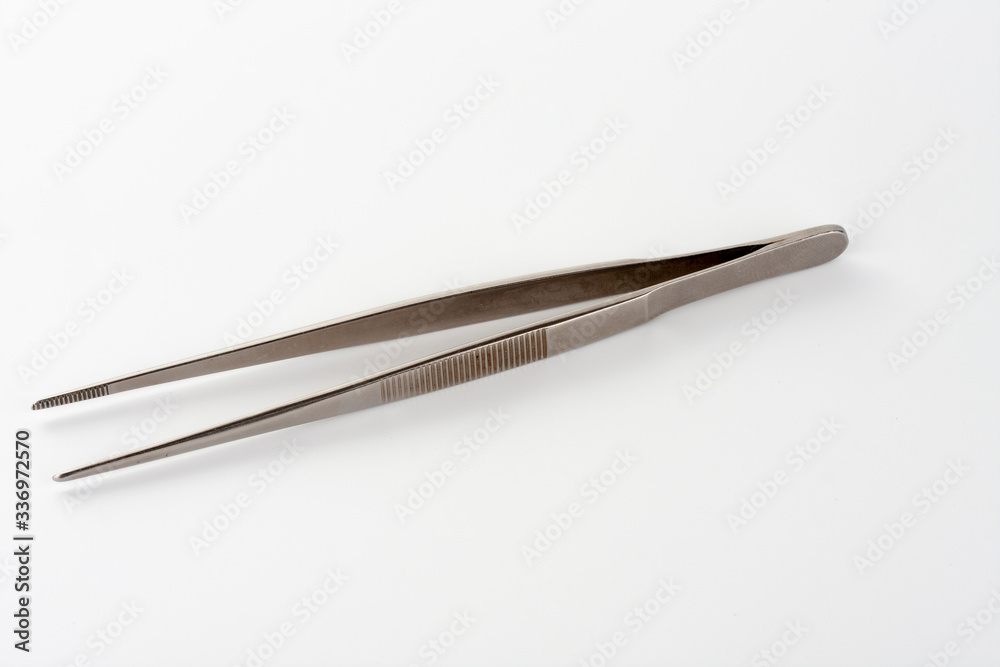 Medical surgical dressing tweezer on white background, tool used in wound treatment in ICU Medical surgical dressing tweezer on white background, tool used in wound treatment in ICU