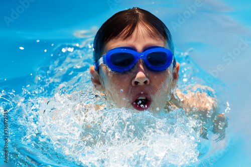 Face swimmer athlete in glasses closeup in drops of water