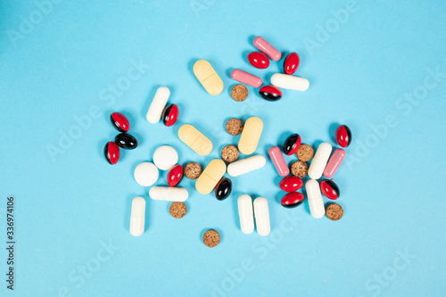 Various medications, tablets, and vitamins. Blue background, place to insert text. Health and pharmacy.