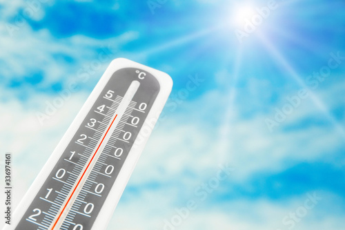 Weather thermometer with high temperature and beautiful sky on background, space for text