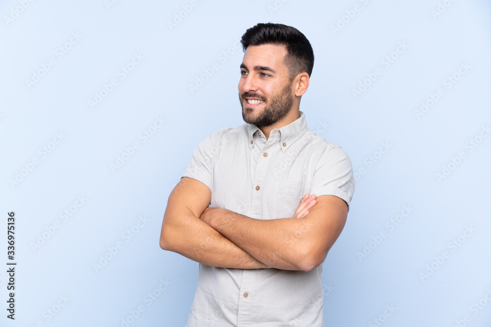 Young handsome man with beard over isolated blue background looking to the side Young handsome man with beard over isolated blue background looking to the side