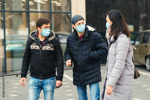 Friends wearing face mask. Covid-2019 outbreak. Coronavirus global pandemic. © volurol