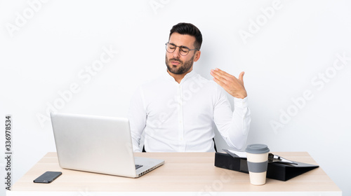 Young businessman in a workplace with tired and sick expression