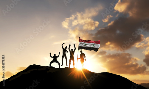 A group of people celebrate on a mountain top with Syria flag. 3D Render