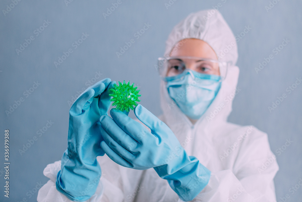 Doctor virologist in a protective suit examines the coronavirus. Close up. Doctor virologist in a protective suit examines the coronavirus. Close up.