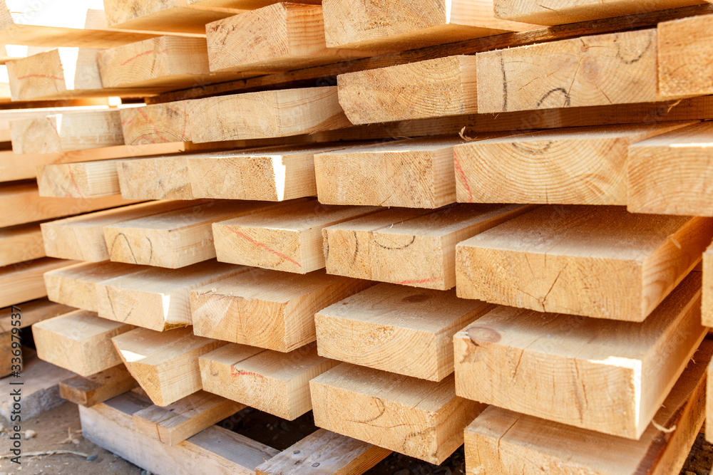 Stack of new wooden studs at the lumber yard. Timber on the