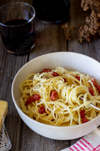 Pasta spaghetti carbonara on a wooden background. Italian cuisine. Recipe. Rustic style. Wine.