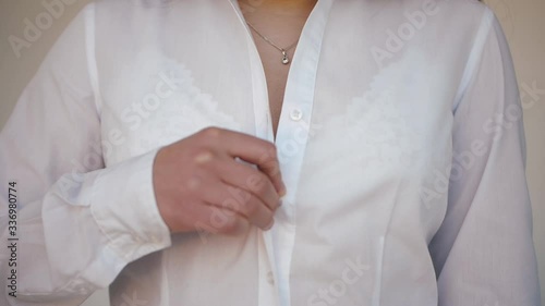 Girl unbuttoning shirt. Undress. Takes off white shirt