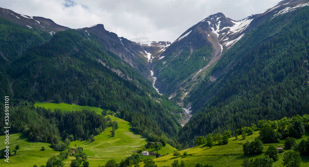 Mountain range. Beautiful view of alpine meadows in the Swiss mountains. Pastures, meadows on the slopes and snow-capped mountains.