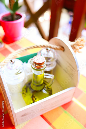 Set in a wooden box of olive oil and spices, salt and pepper peas in a restaurant. Healthy eating concept.