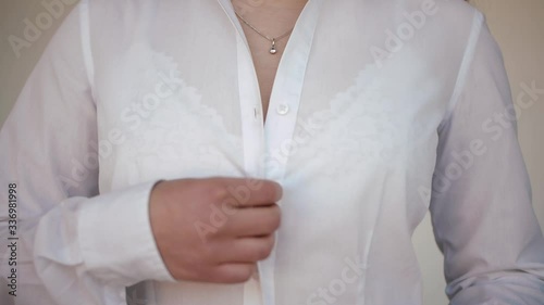 Girl unbuttoning shirt. Undress. Takes off white shirt