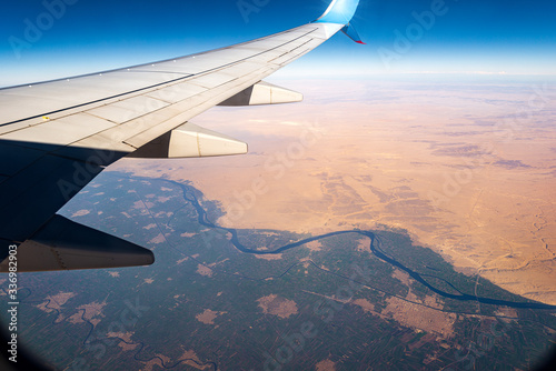 Sahara Desert and the Nile River seen from the plane with the aircraft wing with the Mallawi city, Minya Governorate, Egypt, Africa