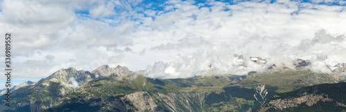 ridges of Swiss mountains panorama in summer, cloudy weather