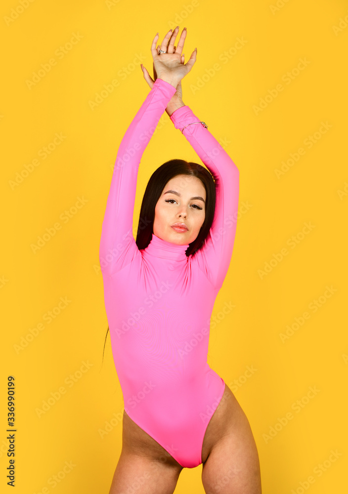Beautiful female. sexy female fashion. woman with slim and fit body. girl wear pink bodysuit yellow background. beauty with retro look. skincare and hair stylish concept. summer trend collection Beautiful female. sexy female fashion. woman with slim and fit body. girl wear pink bodysuit yellow background. beauty with retro look. skincare and hair stylish concept. summer trend collection
