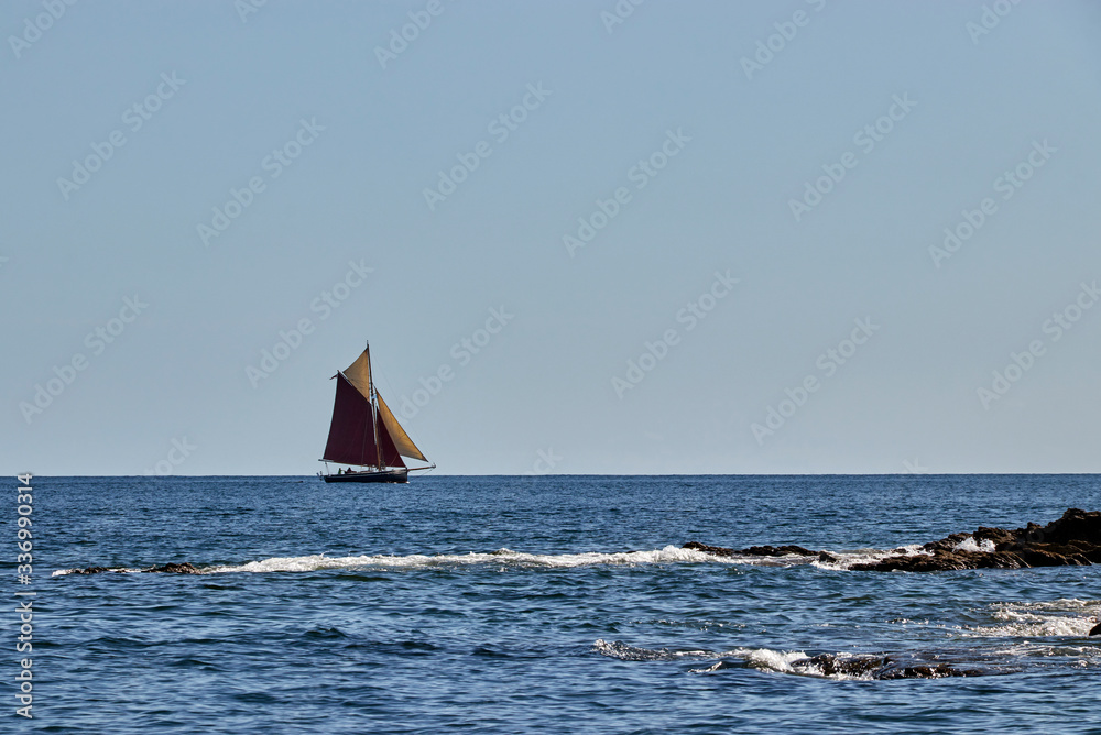 Gaff rigged traditional sailing boat sailing along the English Channel off Cornwall
