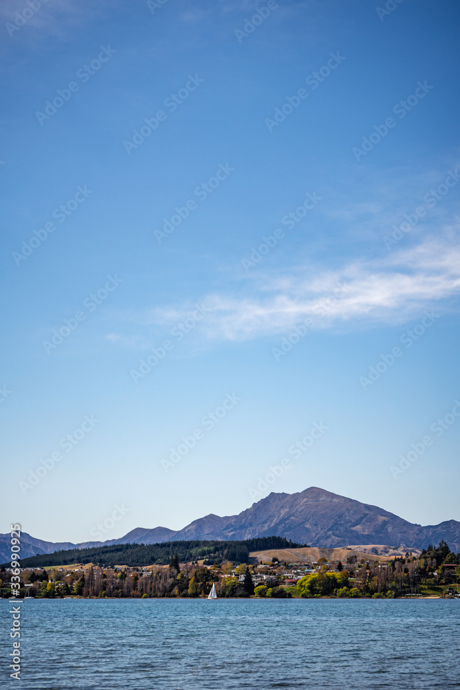 Superb image of a sailboat sailing the famous Wanaka lake on a sunny winter day, New Zealand Superb image of a sailboat sailing the famous Wanaka lake on a sunny winter day, New Zealand