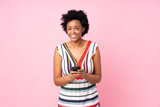 African american woman over isolated pink background sending a message with the mobile