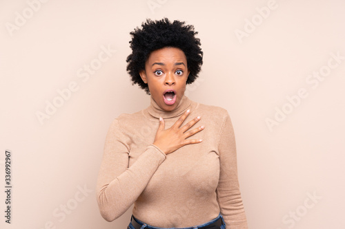 African american woman over isolated background surprised and shocked while looking right