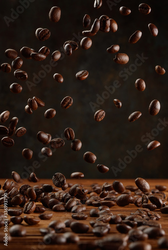 Many roasted coffee beans flying in the air. Selective focus