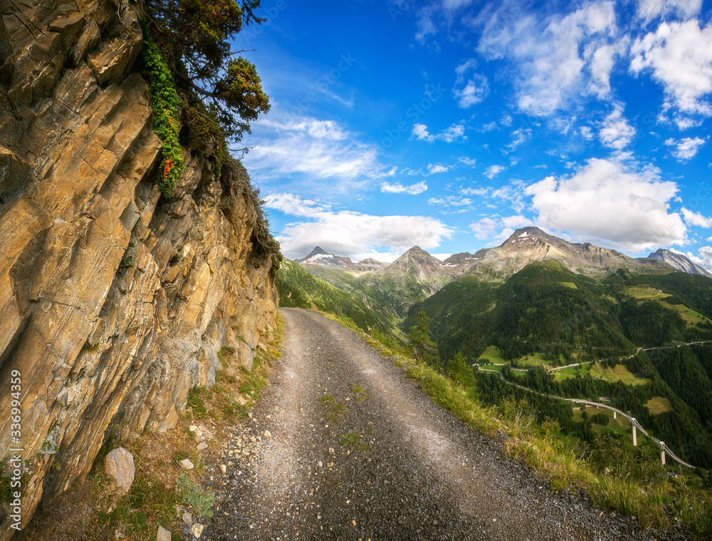dirt road in Switzerland, green meadows and mountains