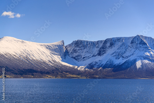 SULA, NORWAY - 2017 APRIL 28. Sunnmore alps with snow on the mountains and blue sky. photo