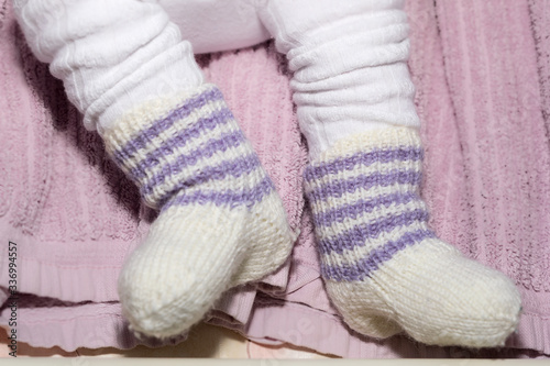 Child's Feet in Hand Knitted White Wool Socks.