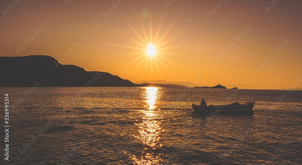 Letni krajobraz na wschód słońca z miasteczka Vinišće w Chorwacji nad morzem Adriatyckim. Wypływający rybak na łowy. 