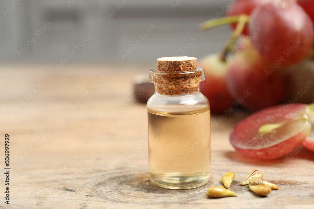 Natural grape seed oil on wooden table, space for text. Organic cosmetic Natural grape seed oil on wooden table, space for text. Organic cosmetic