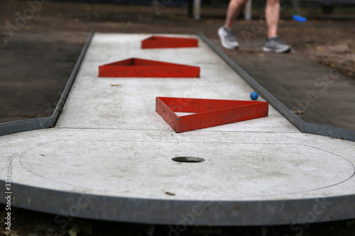 Detail Aufnahme vom Minigolf im Sommer mit einem Blauen Ball auf Grauen Untergrund 