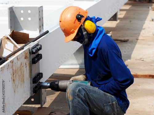Worker using a drill in a construction site