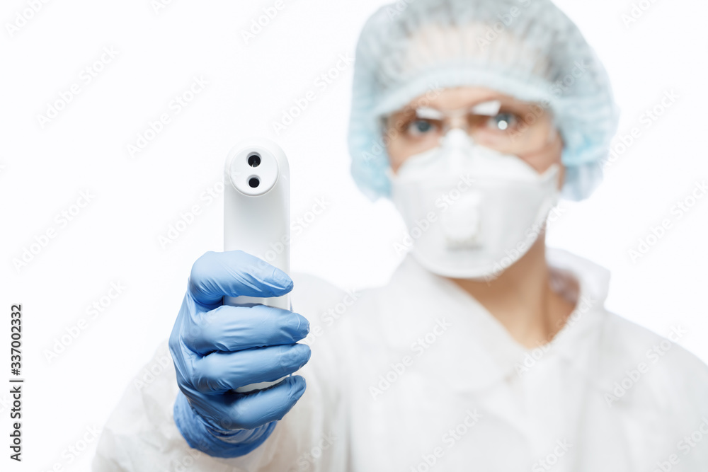 Doctor in protective suit pointing infrared thermometer to check body temperature epidemic virus outbreak concept Doctor in protective suit pointing infrared thermometer to check body temperature epidemic virus outbreak concept