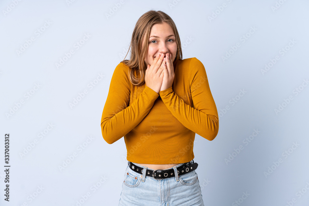 Teenager Ukrainian girl isolated on blue background happy and smiling covering mouth with hands Teenager Ukrainian girl isolated on blue background happy and smiling covering mouth with hands