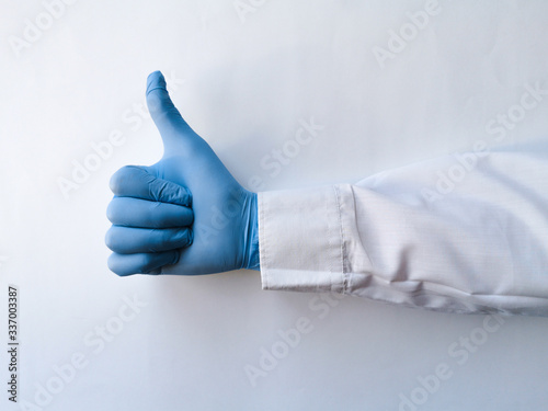 Hand of a medical worker shows thumb up on white isolated background. Hand gestures. Close-up of a hand showing thumb up.