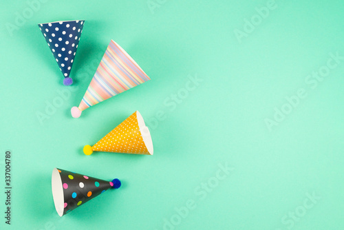 Colorful birthday caps on mint background.