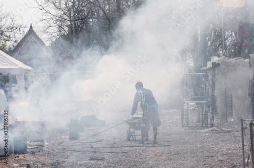 Unidentified workers are working in haze areas that are harmful to health, dust value PM 2.5. Pollution causes global warming. Workers preparing to smelt gold for casting Buddha statues