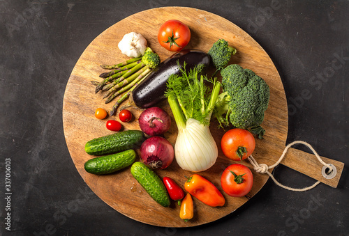 Exposition of fresh organic vegetables on wooden plate. tomato, pepper, broccoli, onion, garlic, cucumber,  eggplant, black Eyed Peas, ecological bag.